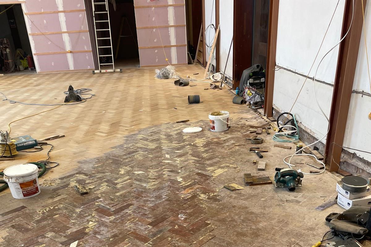 Photo of flooring in a large hall which in the process of being restored by sanding and oiling, performed by SR Flooring in Edinburgh