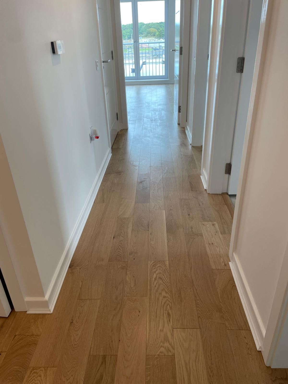 Photo of newly laid hardwood flooring in a hallway, performed by SR Flooring in Edinburgh